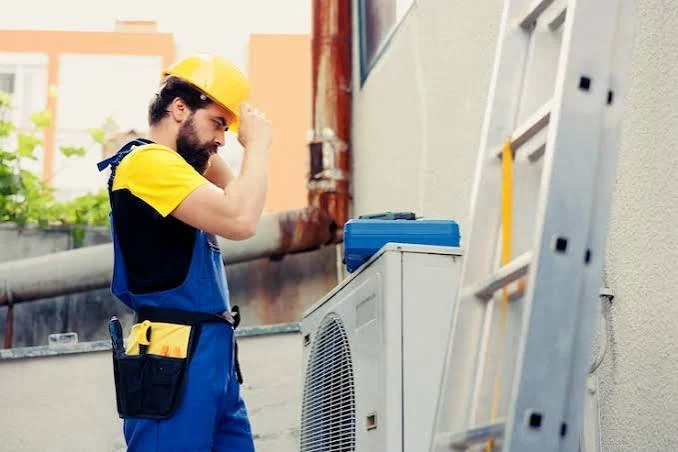 HVAC installation technician working beside an outdoor condenser